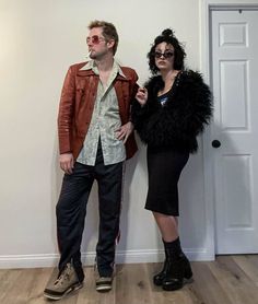 a man and woman standing next to each other in front of a door wearing sunglasses