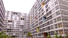 two tall buildings with windows and balconies on the sides