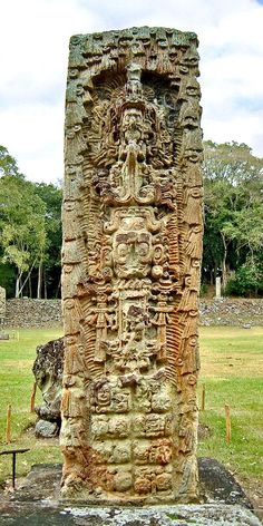 an ancient statue in the middle of a field