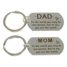 two metal key chains with the words dad and mom on them, one has a heart shaped