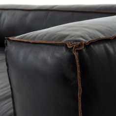 a black leather couch with brown stitching on it