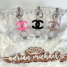 three chandelier keychains sitting on top of a white furry surface