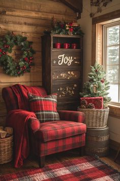 a red chair sitting in front of a window next to a christmas tree and wreath