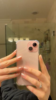 a woman taking a selfie with her cell phone in the mirror while wearing rings