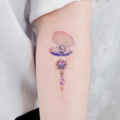 a woman's arm with a tattoo on it that has an image of a shell