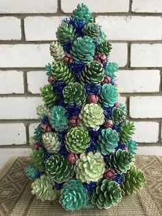 a christmas tree made out of pine cones and succulents on a table