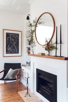 a living room with a fire place and a mirror on the wall