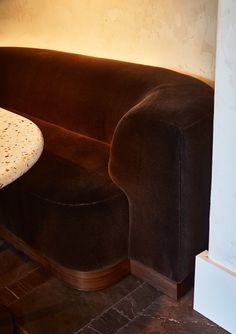 a brown couch sitting next to a white table