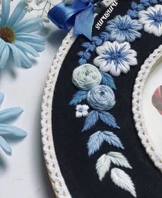 a close up of a plate on a table with flowers in the background and a blue ribbon around it