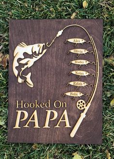 a wooden sign that says hooked on papa with fish and fishing hooks attached to it