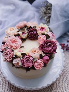 a white cake with pink and red flowers on it