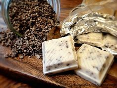 three pieces of soap sitting on top of a wooden cutting board next to a jar