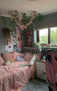 a bedroom with pink bedding and lots of plants hanging from the ceiling above it