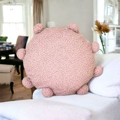 a pink pillow sitting on top of a white couch