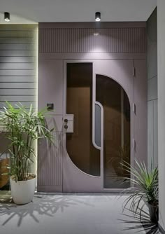 an entrance to a building with plants and potted plants on the floor next to it