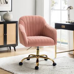 a pink chair sitting on top of a white rug in front of a desk and window