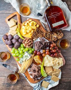 an assortment of wine, cheese and crackers on a wooden table