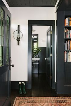 an entryway with bookshelves and a rug on the floor in front of it