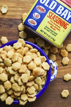 a blue bowl filled with old bay seasoning next to a container of seasoned tater tots