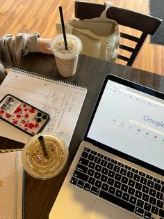 an open laptop computer sitting on top of a wooden table next to a cup of coffee