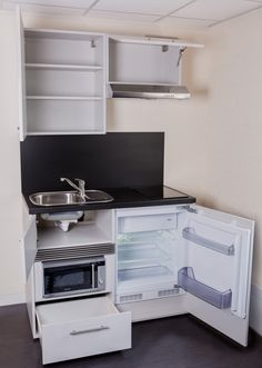 a small kitchen with an open refrigerator and sink