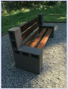 a wooden bench sitting on top of a gravel field