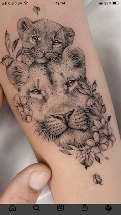 a woman's arm with a tattoo on it and two lions in the middle