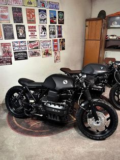 two motorcycles are parked next to each other in a room with posters on the wall