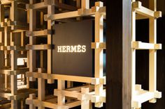 there is a sign that says hermes on it in front of some wooden shelves