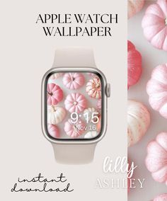 an apple watch with pink and white flowers on the screen, next to some small pumpkins