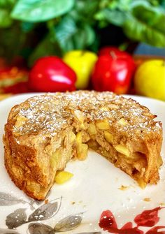 an apple pie is cut in half on a plate next to some apples and leaves