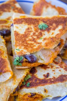 several quesadillas stacked on top of each other in a white and blue plate