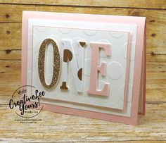 a pink and white card with the word love in gold foil on it's corner