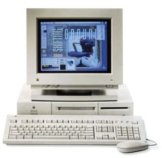 an old desktop computer sitting on top of a desk next to a keyboard and mouse