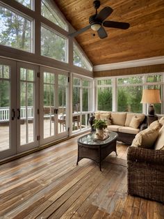 a living room filled with furniture and lots of glass doors leading to a covered porch