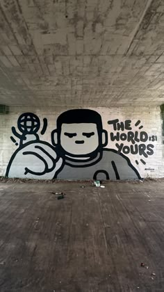 graffiti on the side of a building under a bridge