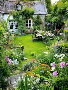 the garden is full of colorful flowers and greenery, including an old - fashioned house