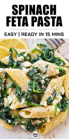 spinach fetta pasta with lemon wedges on the side