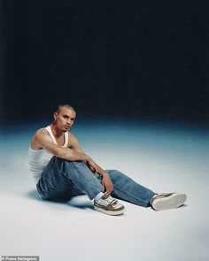 a man sitting on the ground with his legs crossed and one foot up in the air