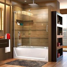 a bathroom with a glass shower door and wooden flooring, along with a rug on the floor