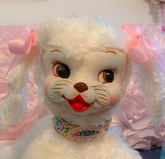 a close up of a stuffed animal on a bed with pink and blue sheets behind it