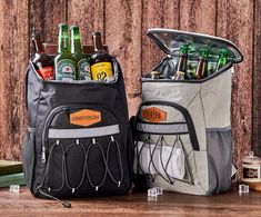 two cooler bags filled with beer bottles sitting on top of a wooden table next to each other