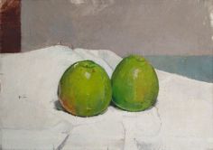 two green apples sitting on top of a white cloth