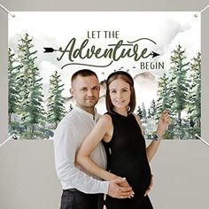 a man and woman standing next to each other in front of a sign that says let the adventure begin