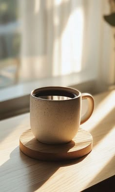 a coffee cup sitting on top of a wooden coaster