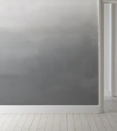 an empty room with white walls and wooden floors