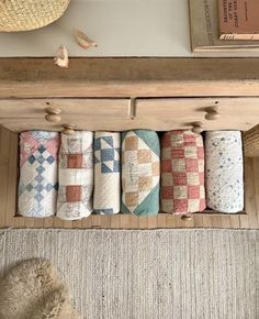 a bunch of towels that are hanging on a rack in a room next to a rug