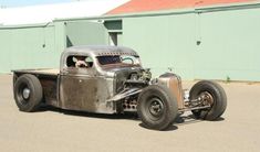 an antique hot rod car parked in front of a building