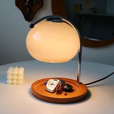 a lamp that is sitting on top of a wooden plate next to some marshmallows