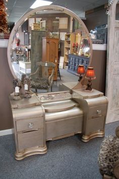 a mirror sitting on top of a dresser next to a table with drawers and chairs